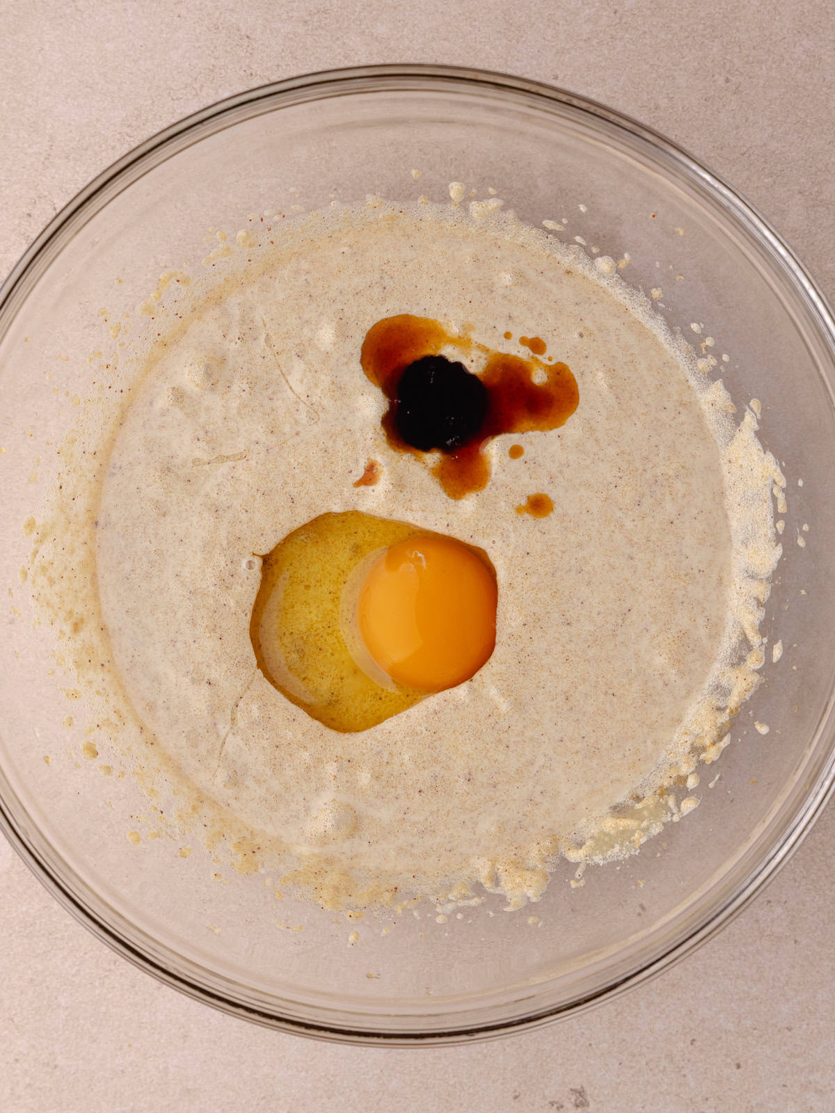 An egg and vanilla extract is added to the bowl with butter/sugar mixture.