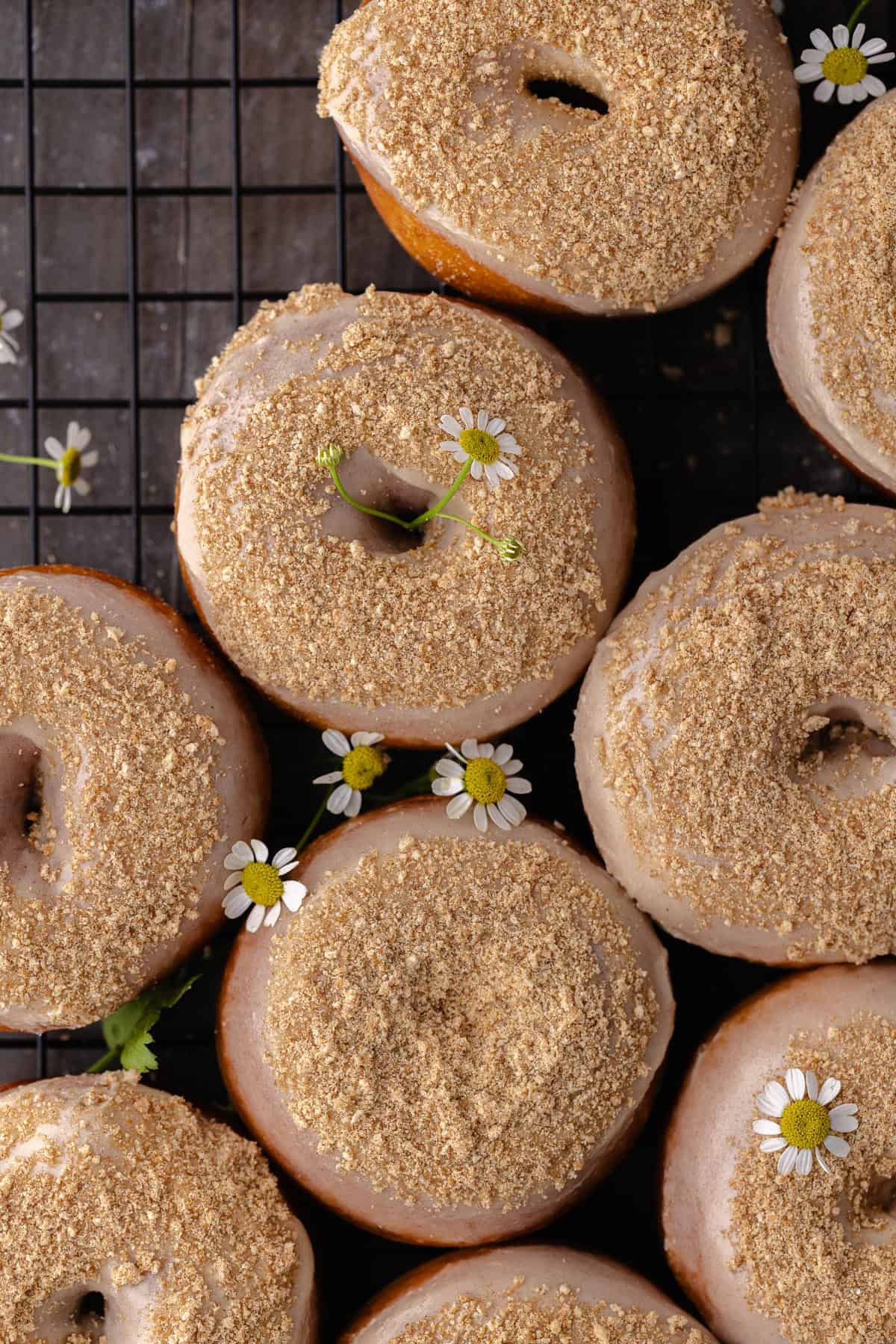 Glazed cinnamon toast crunch donuts sitting on a wire rack.