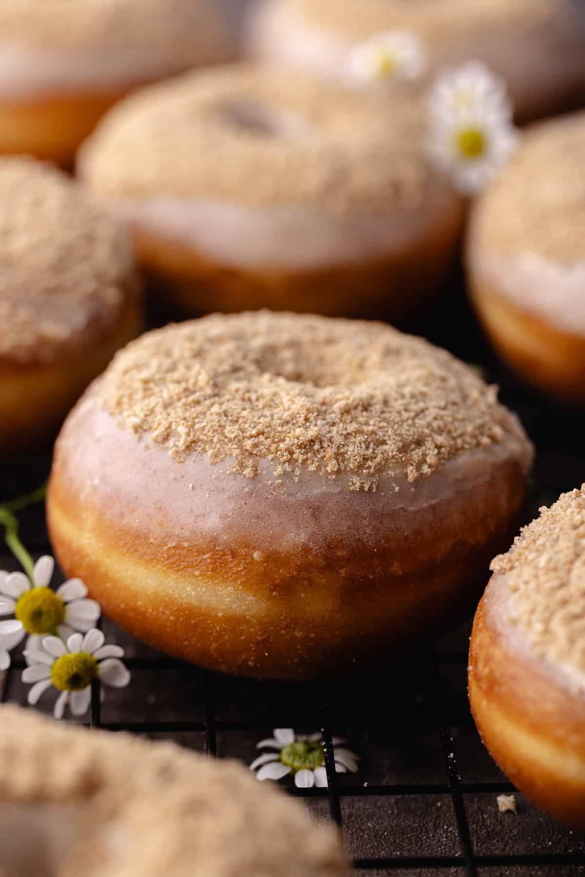 Glazed cinnamon toast crunch donuts sitting on a wire rack.