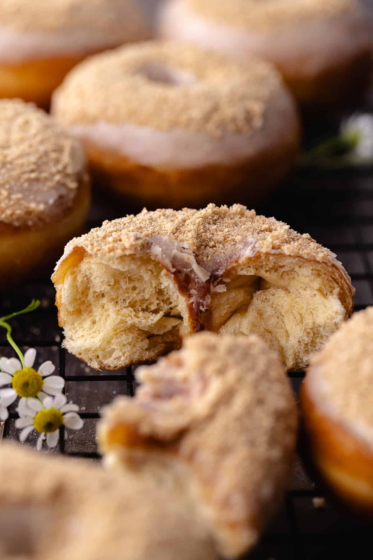 A close up of a glazed cinnamon toast crunch donuts sitting on a wire rack.