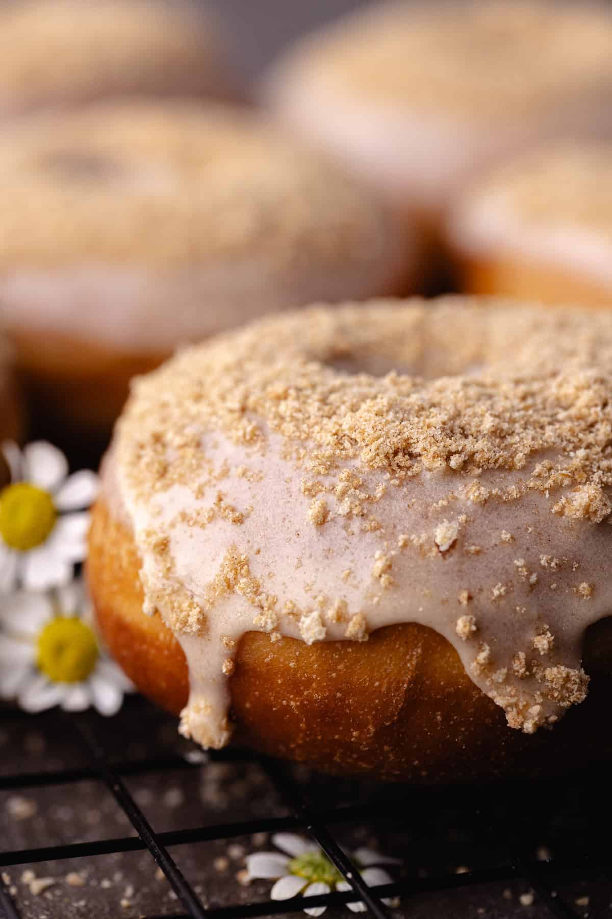 A close up of Glazed cinnamon toast crunch donuts sitting on a wire rack.