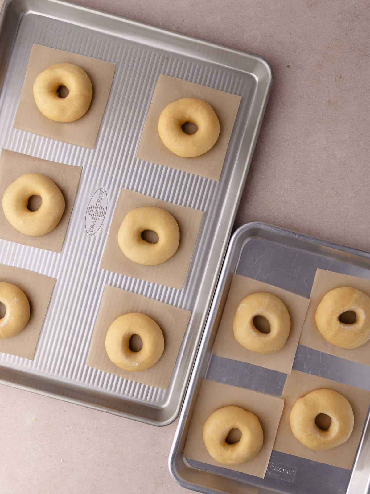 Donuts are shaped and sitting on 2 baking sheets.