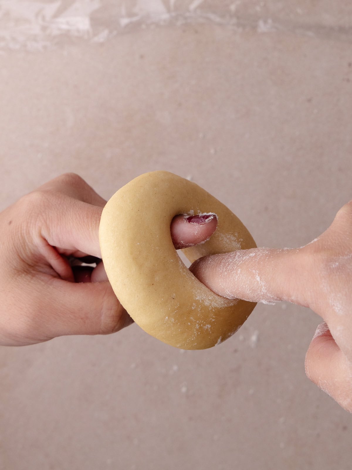 Donuts are twirled around 2 fingers to create a whole in the center.