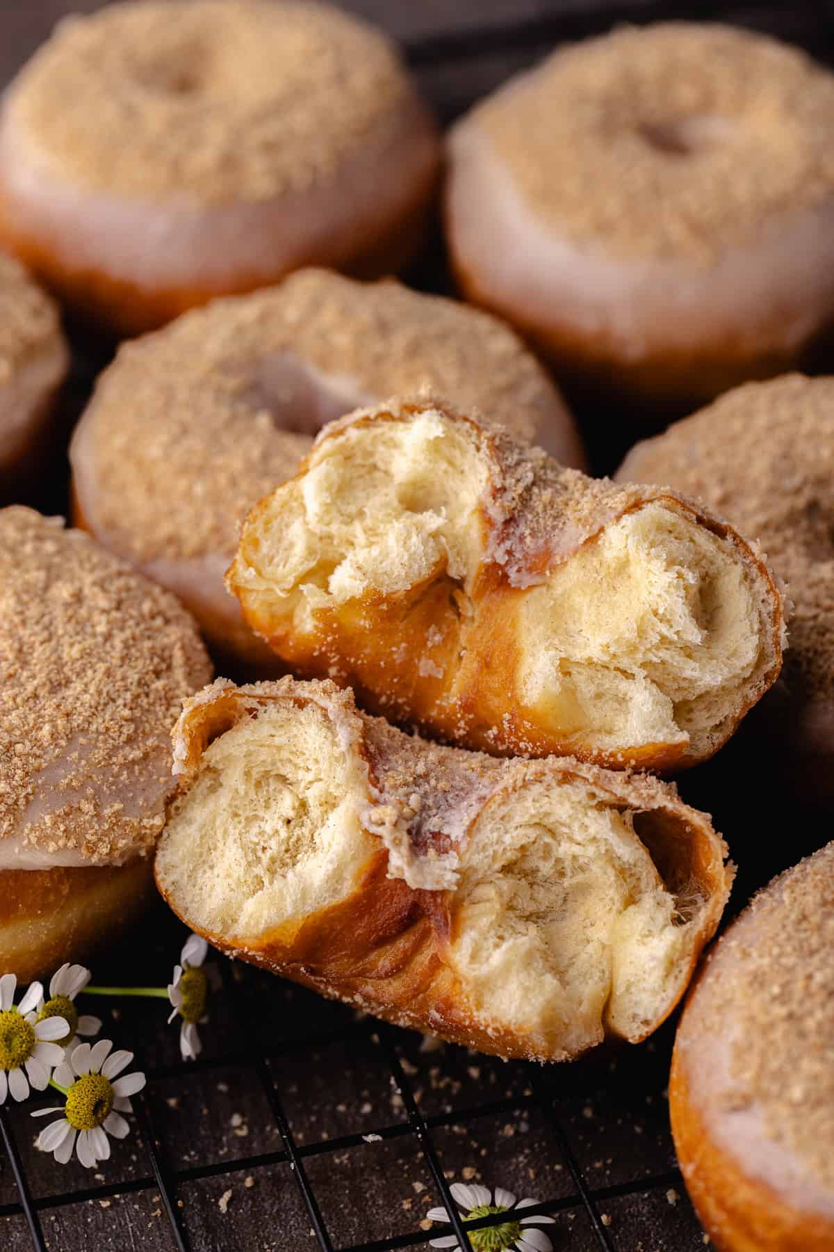 Cinnamon toast crunch donuts sitting on a wire rack.