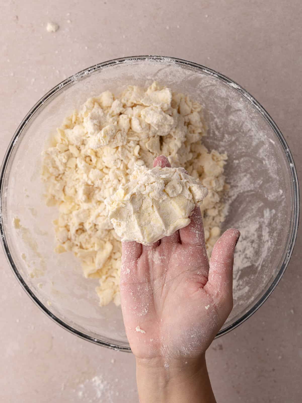 Pie dough is squeezed together with the hands.