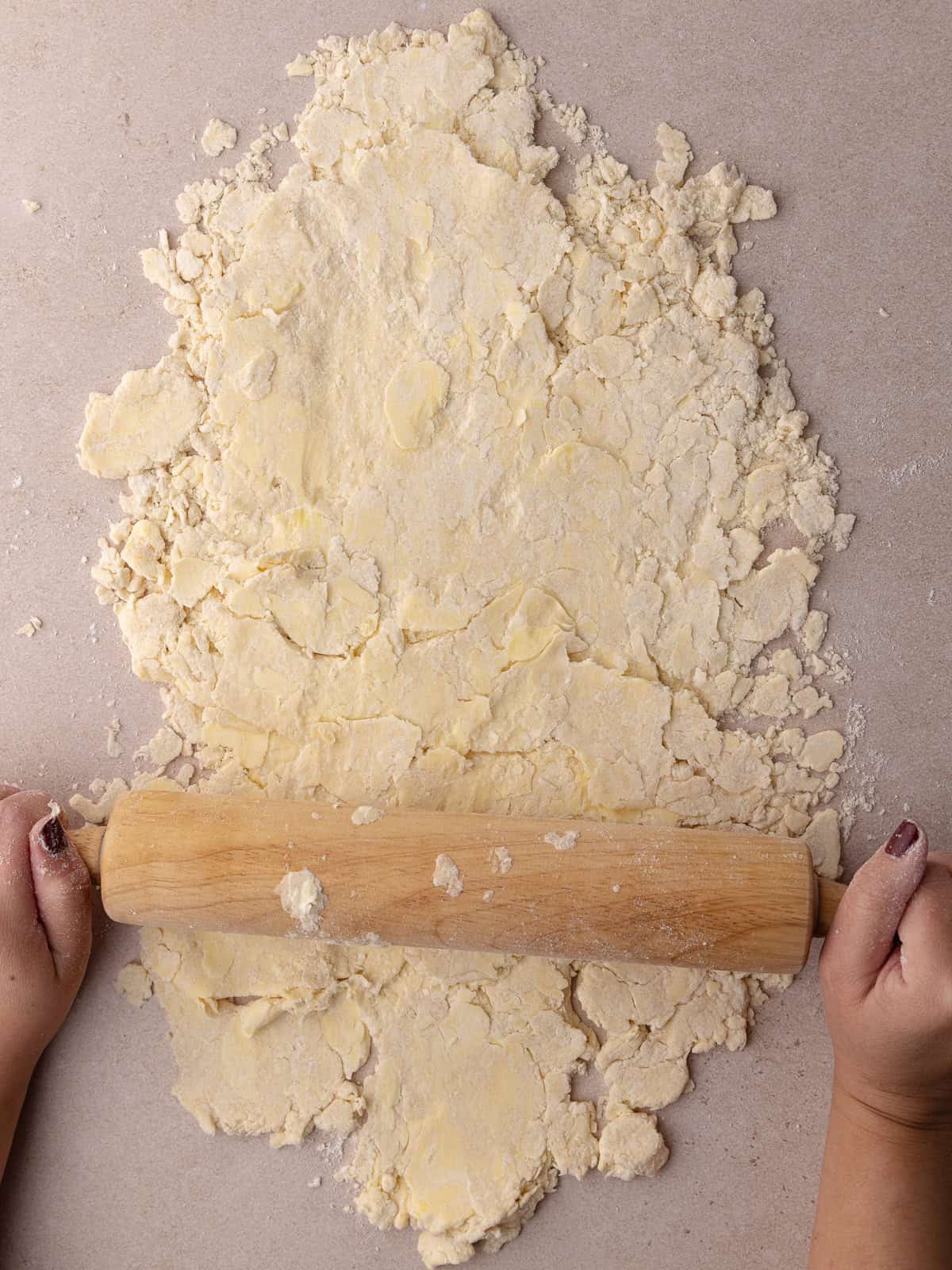 A rolling pin flattens the pie dough mixture.