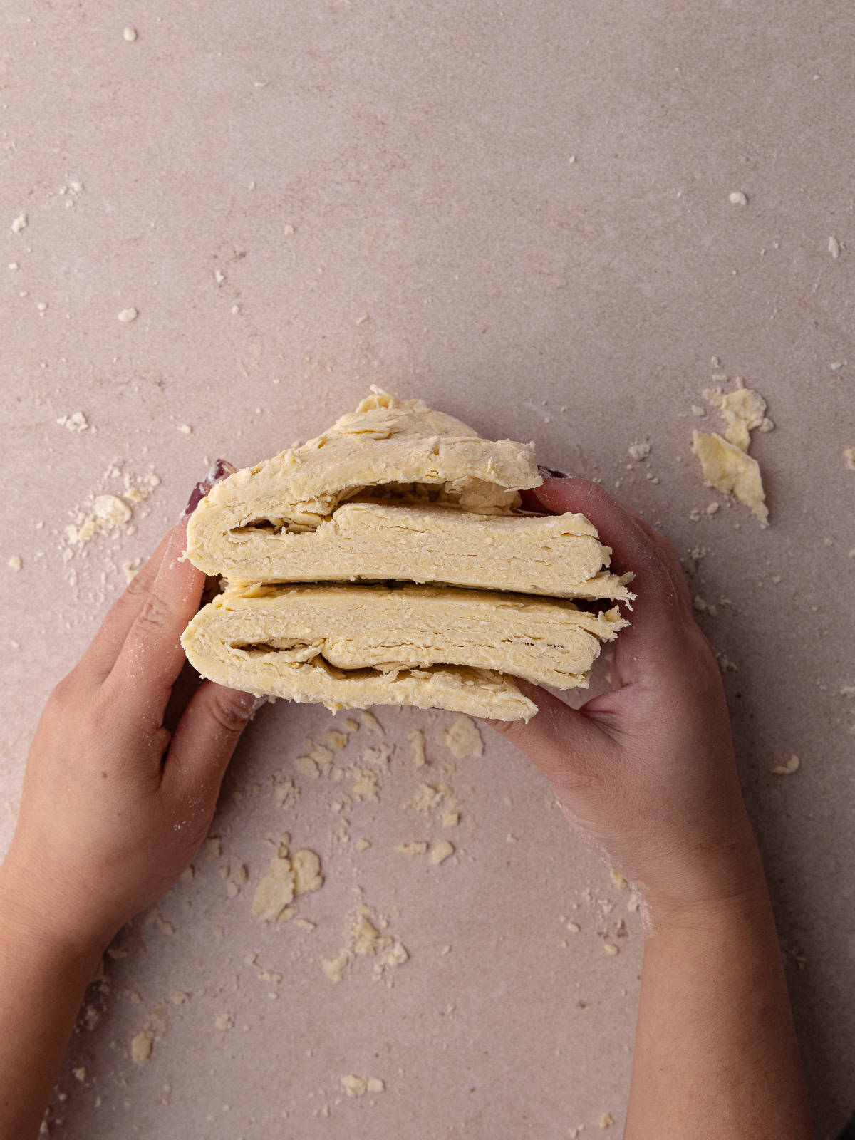 The pie dough is cut into 2 equal pieces and layers are exposed.