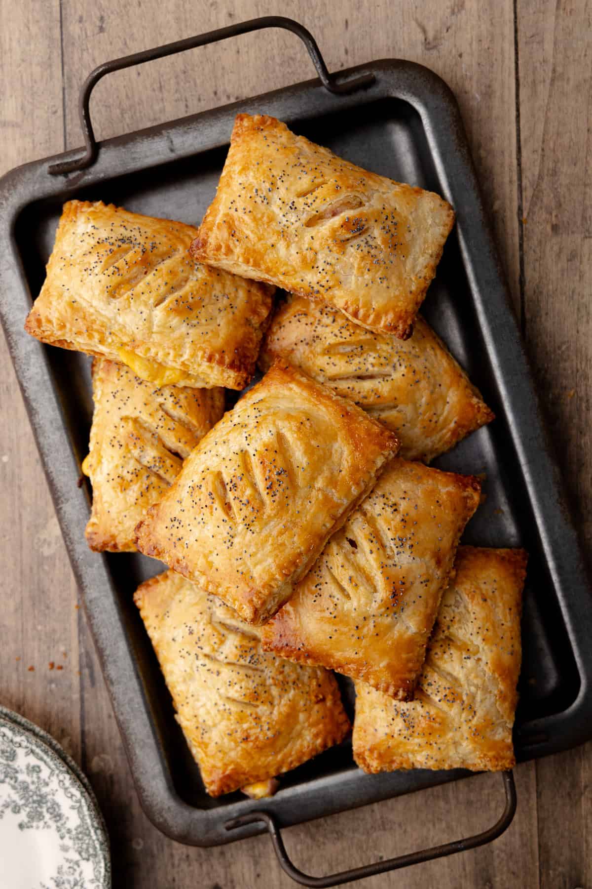 Super flaky and tender ham and cheese hand pies sitting on a serving tray.