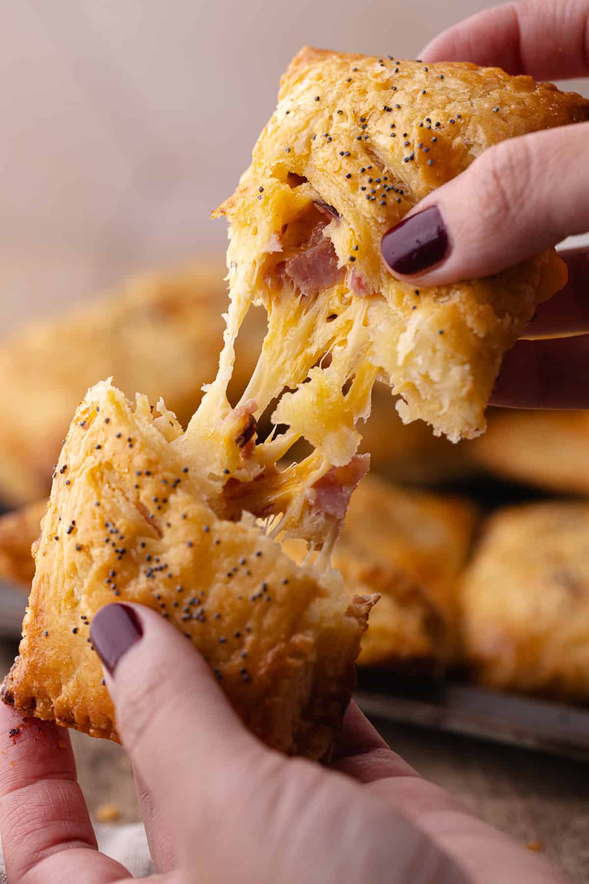 Super flaky and tender ham and cheese hand pie is slip open to show cheesy filling.