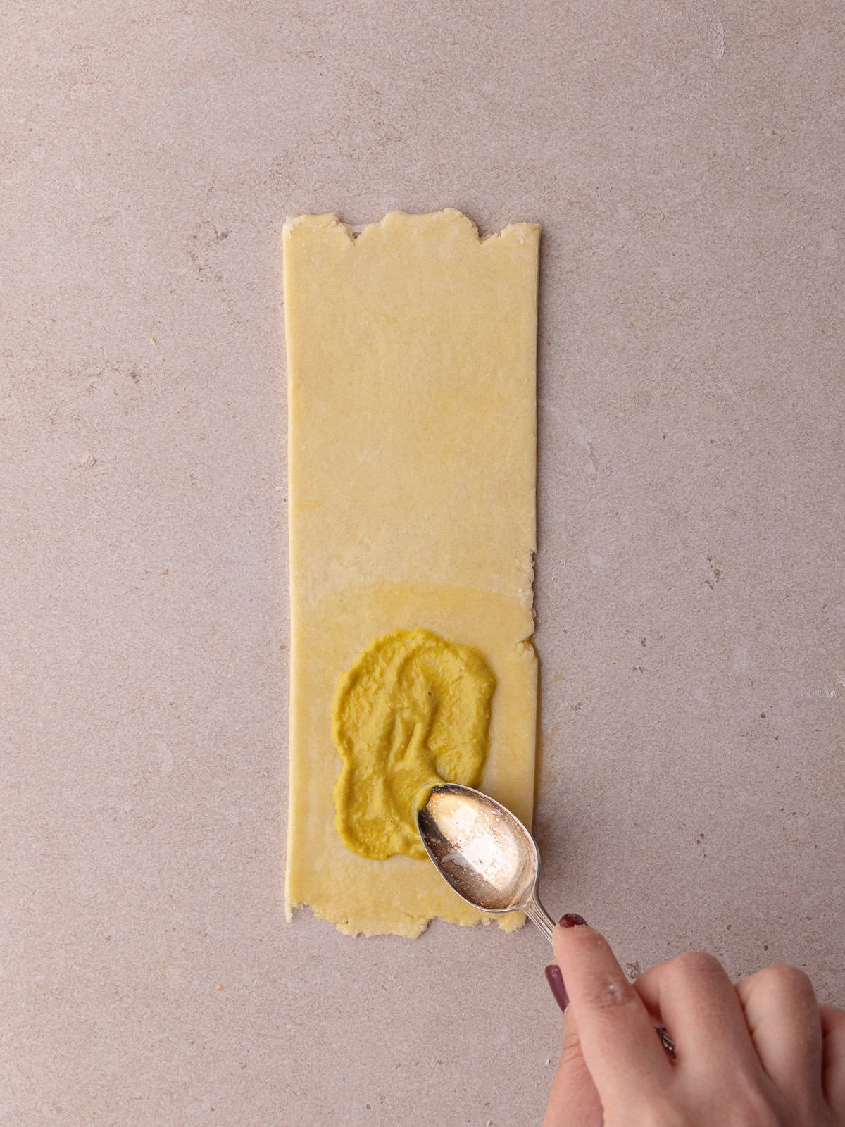 A teaspoon of yellow mustard is added to the pie dough.