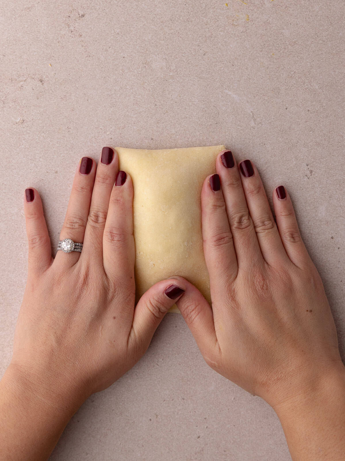 Hands presses the 2 pieces of pie dough together.