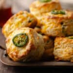 Tall flaky buttermilk Jalapeño cheddar biscuits sitting on a serving tray feature photo.