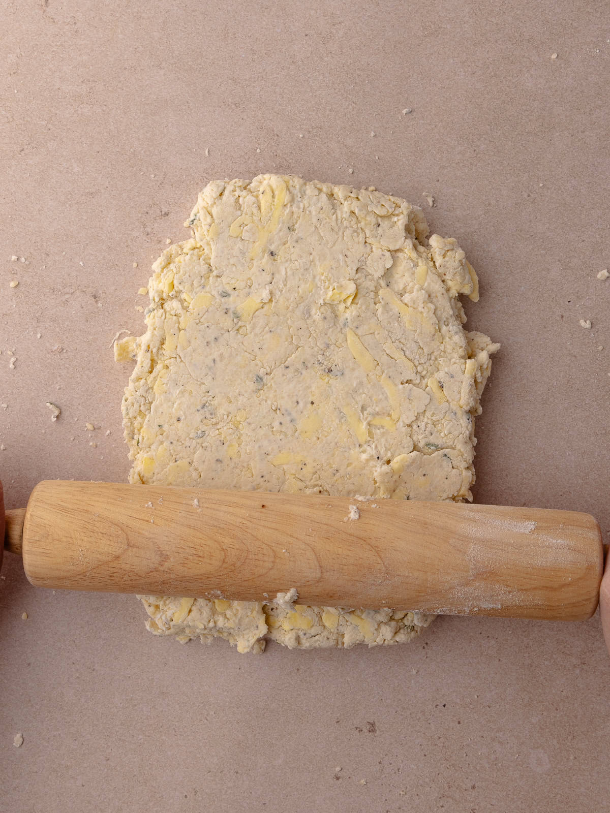 The biscuit dough is rolled flatt with a rolling pin.