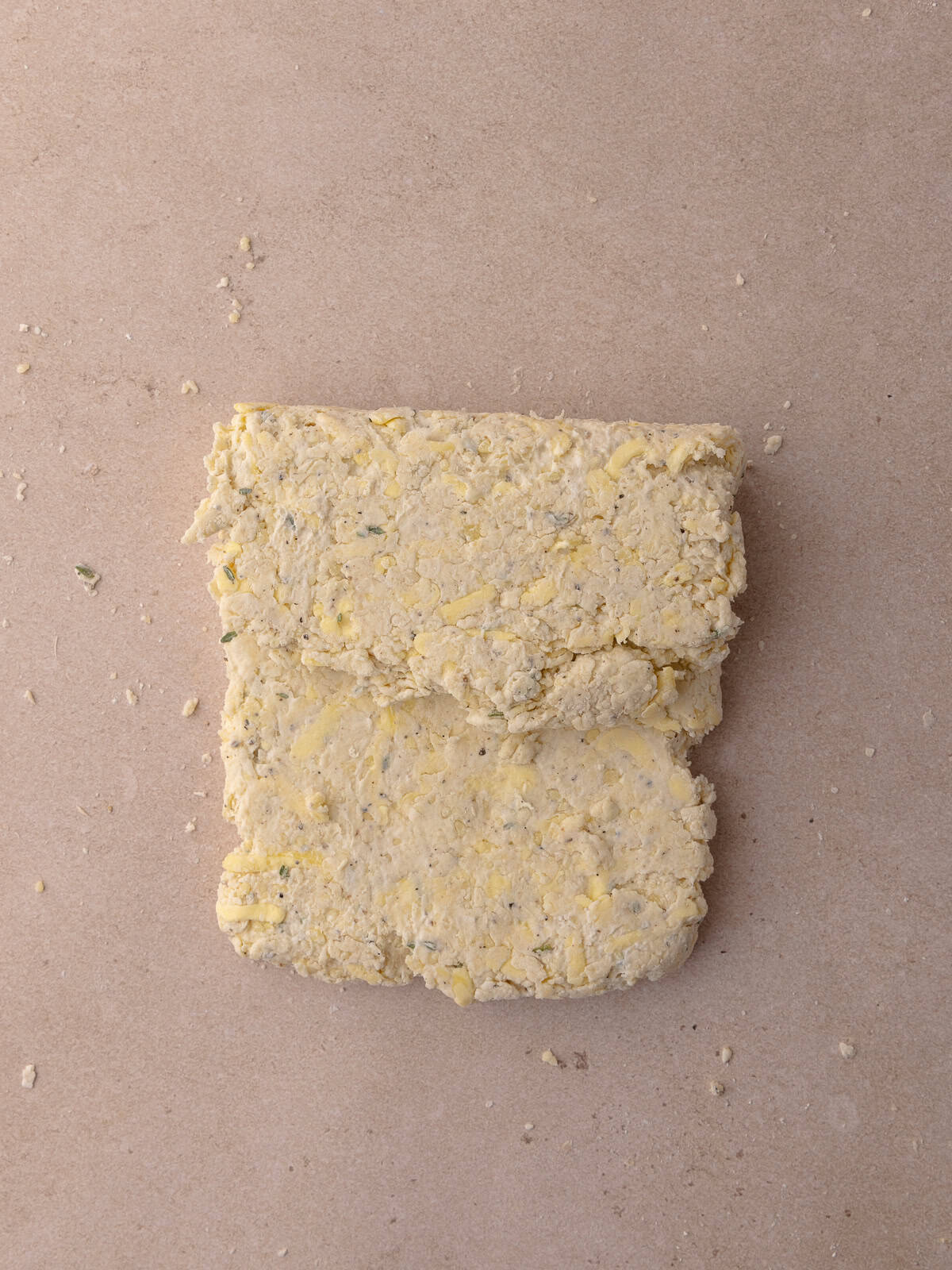 The top third of the thyme biscuit dough is folded over and onto itself.