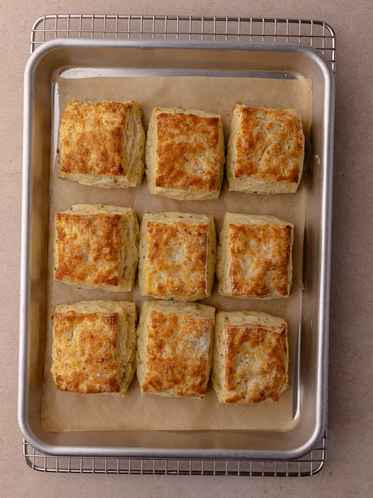 Thyme biscuits are baked until golden brown and are sitting on a baking tray.