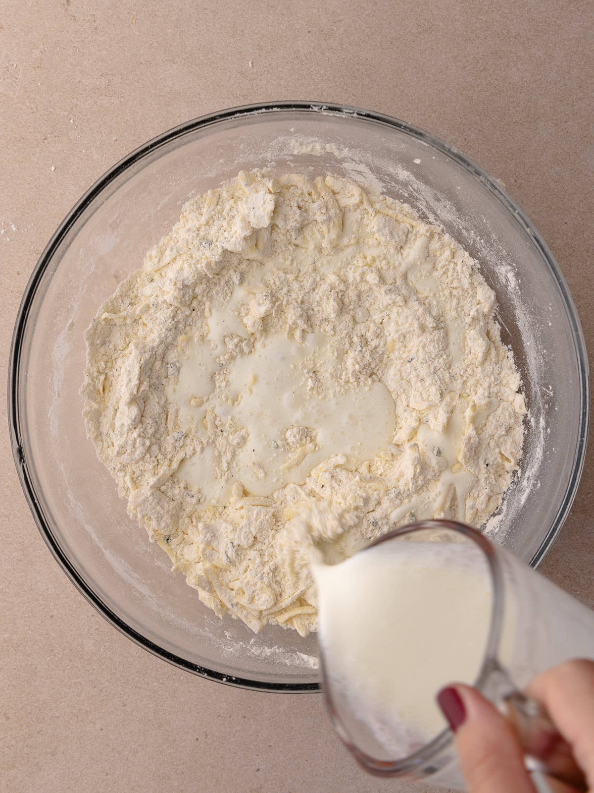 Cold buttermilk is poured into the flour mixture.