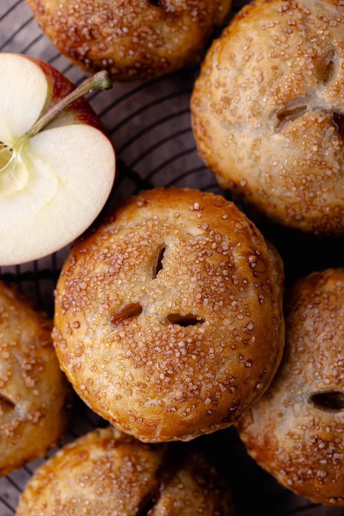 Puff pastry apple hand pies sits on a wire rack.