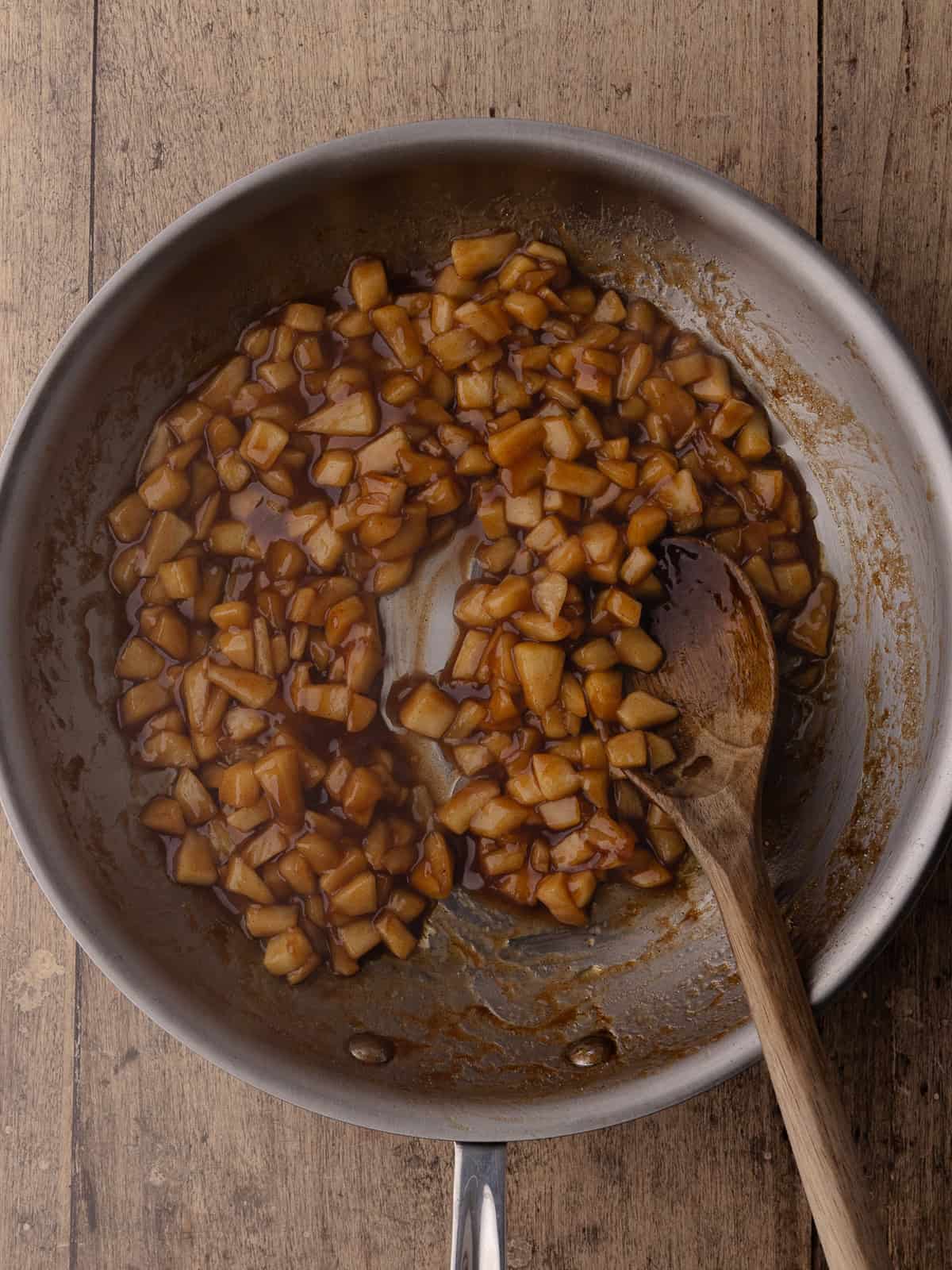 Diced apples are cooked in a pan.