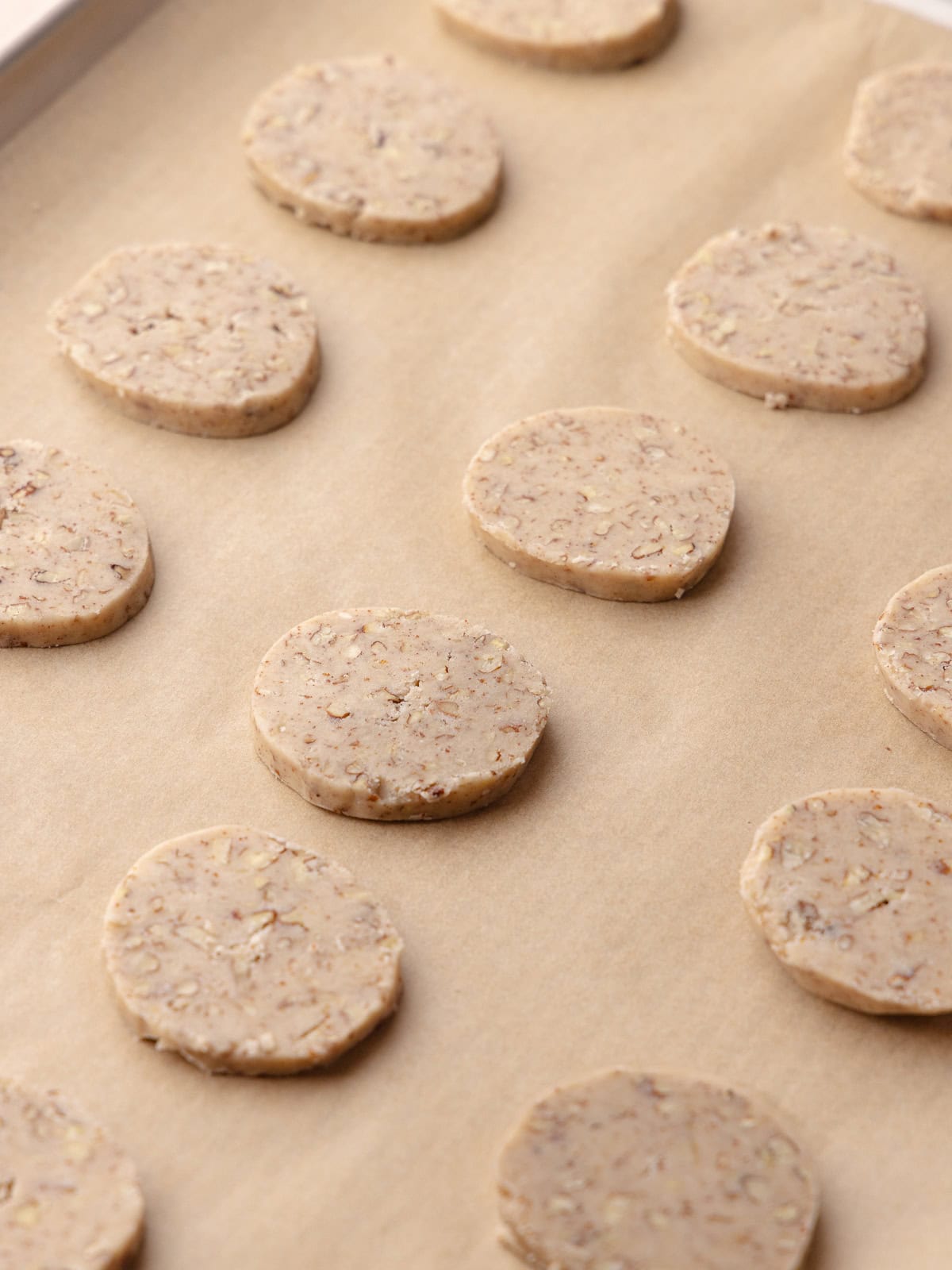 Sliced brown butter pecan cookies sitting on a baking tray and ready to be baked in the oven.