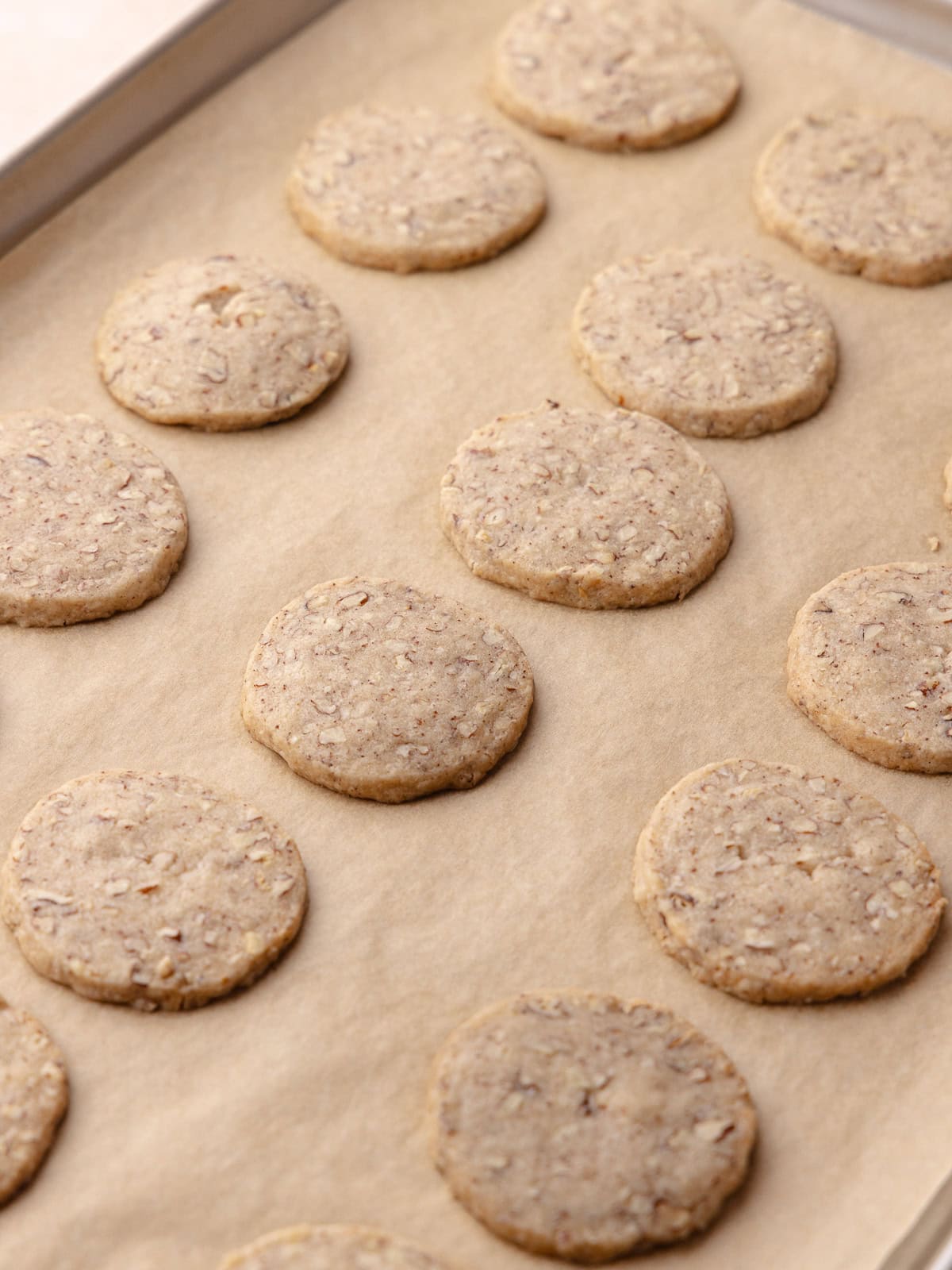 Brown butter pecan cookies are baked and sitting on a baking tray.