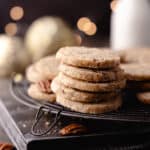 Brown butter pecan cookies with maple and cinnamon, stacked and sitting on a wire rack feature photo.