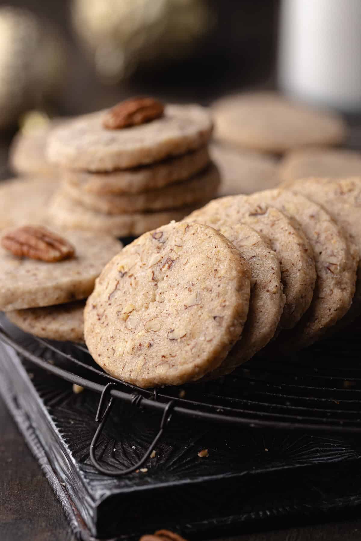 Brown butter pecan cookies with maple and cinnamon sitting on a wire rack.