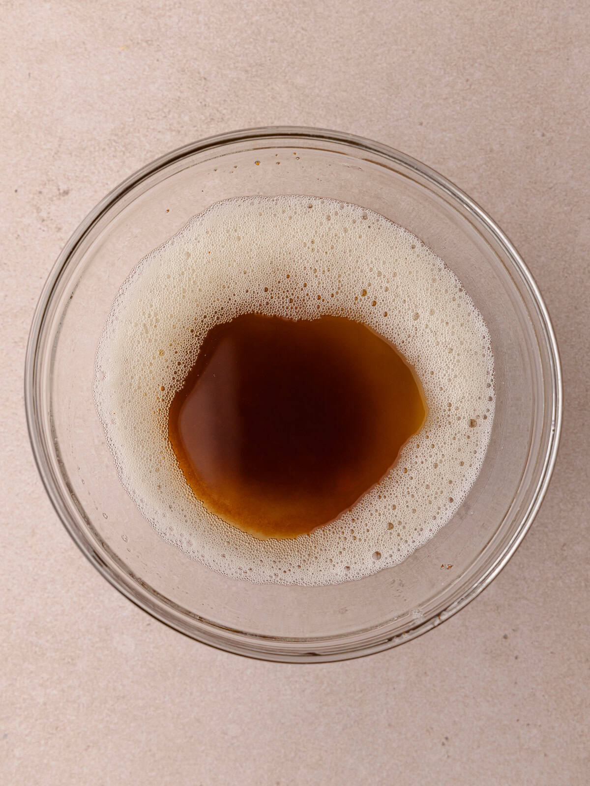 Brown butter is poured into a small glass bowl.