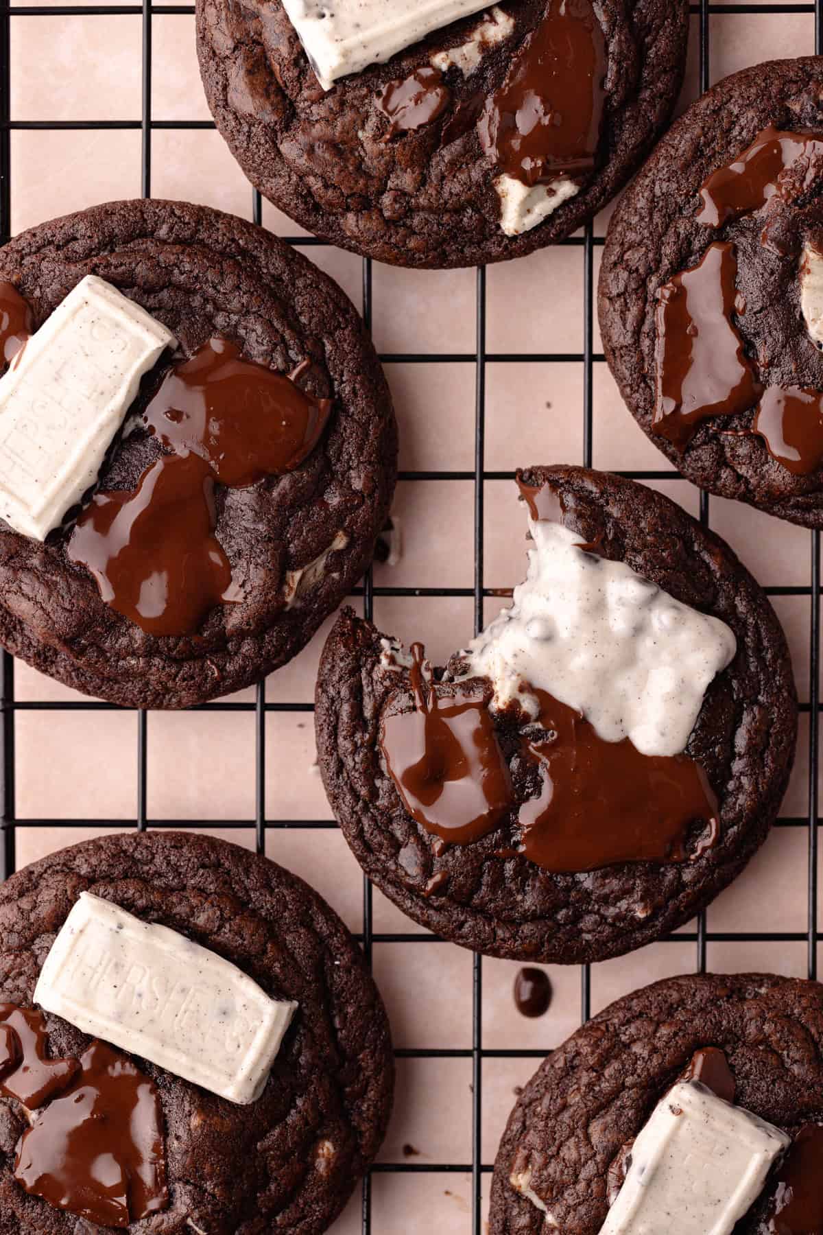 Chocolate cookies and cream cookies sitting on a wire rack.