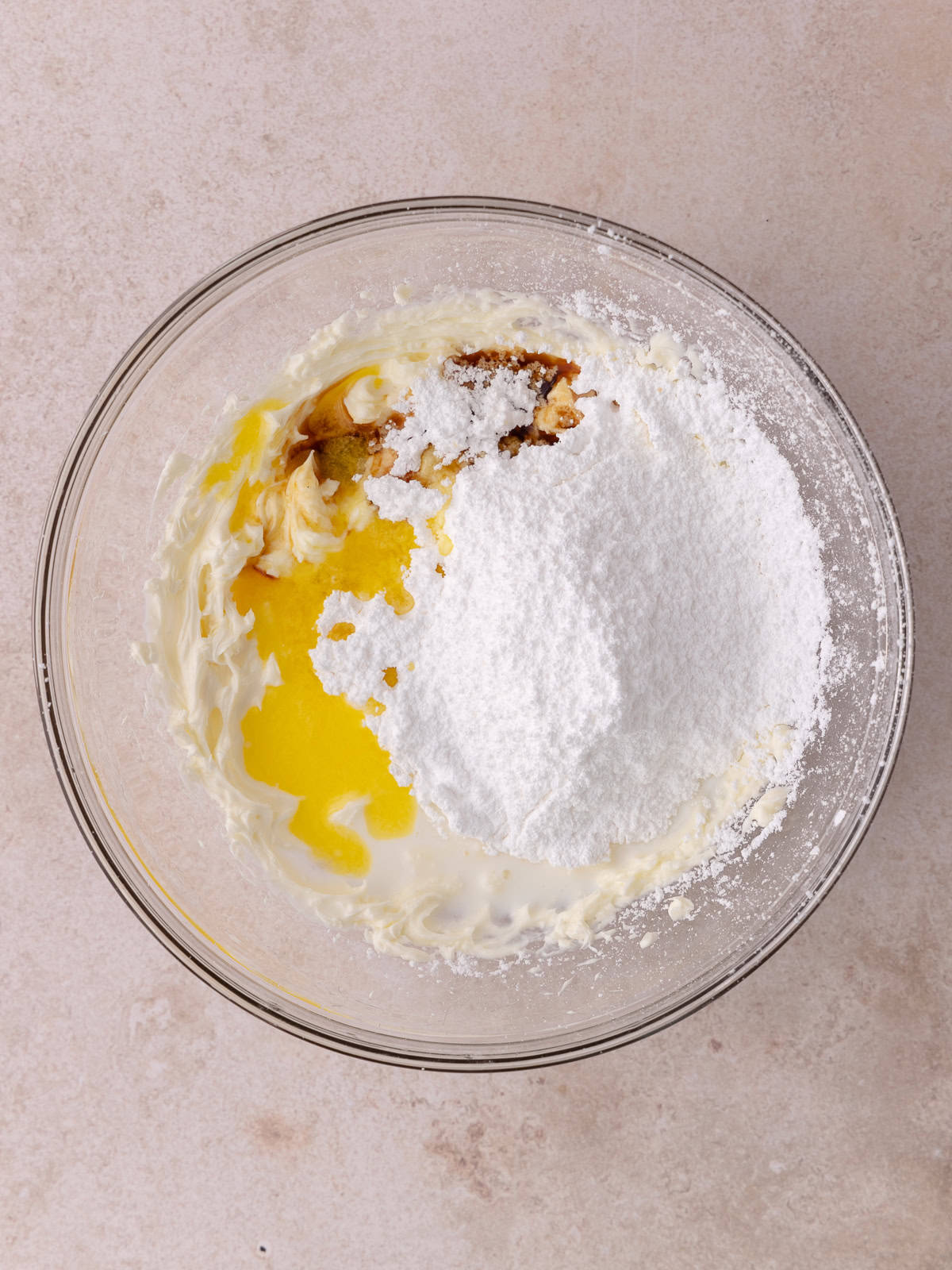 Cream cheese, powdered sugar, melted butter, vanilla and milk are in a medium mixing bowl.