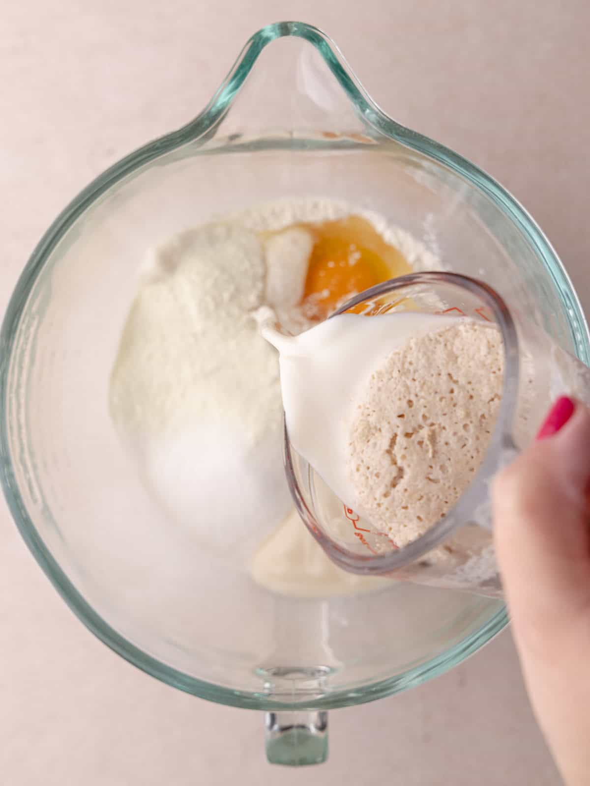 Frothy yeast mixture is added to the bowl with all the Giant cinnamon roll cake dough.