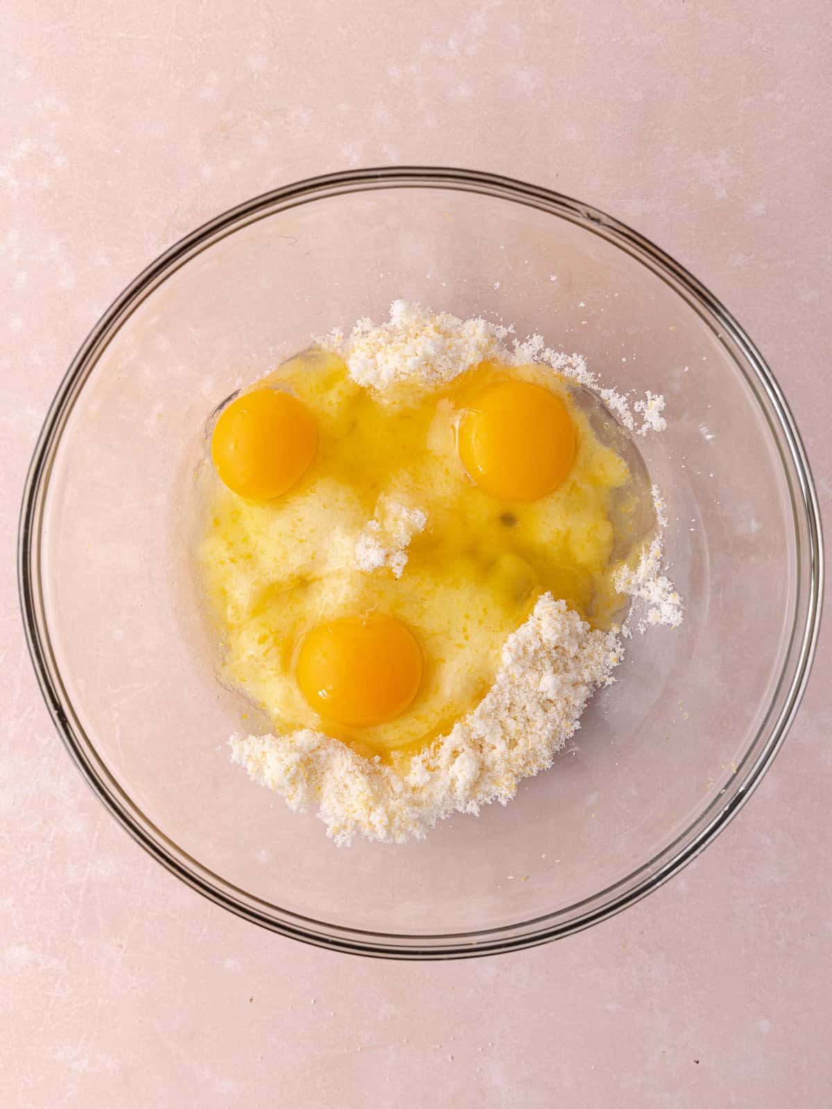 Three whole eggs are added to the sugar/grapefruit zest mixture.