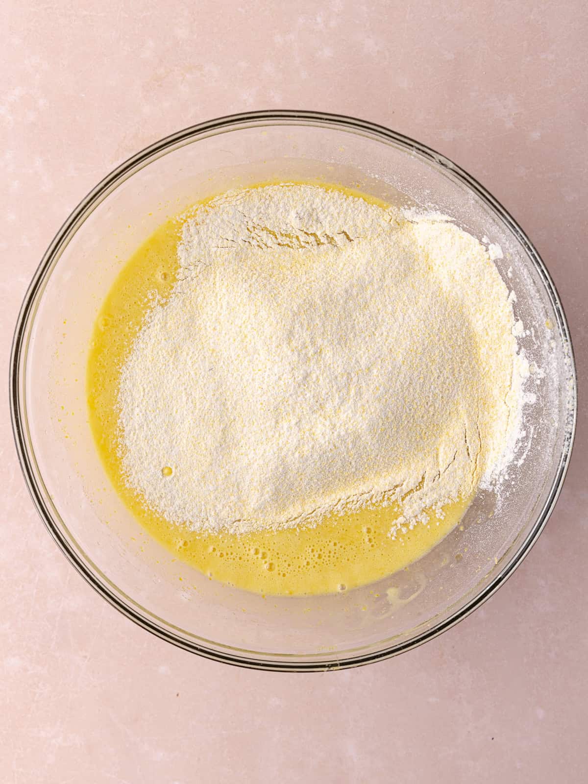 Dry ingredients, which include all-purpose flour, polenta, baking powder and salt, are sifted into the wet ingredients.