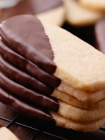 Macadamia nut shortbread also known as, hawaiian shortbread cookies are dipped in chocolate and sitting on a wire rack feature photo.