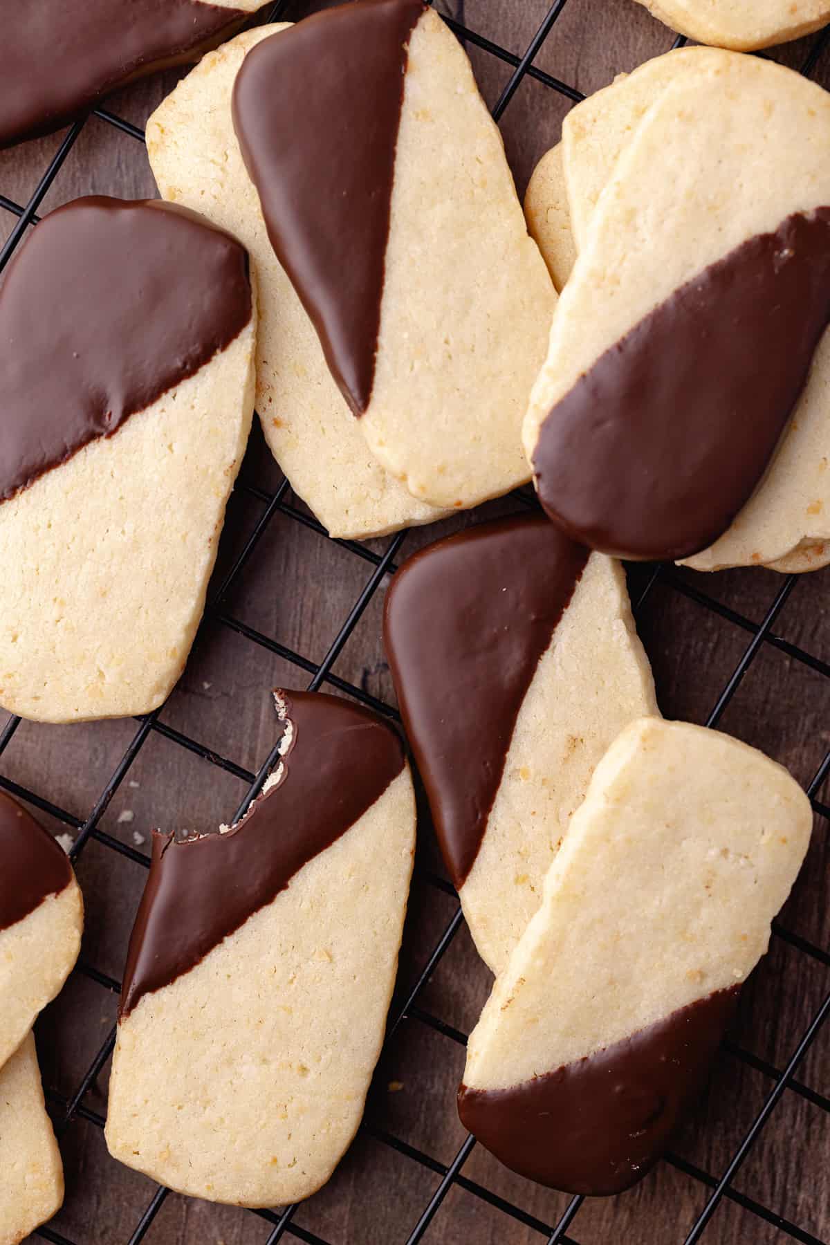 Macadamia nut shortbread also known as, hawaiian shortbread cookies are dipped in chocolate and sitting on a wire rack.