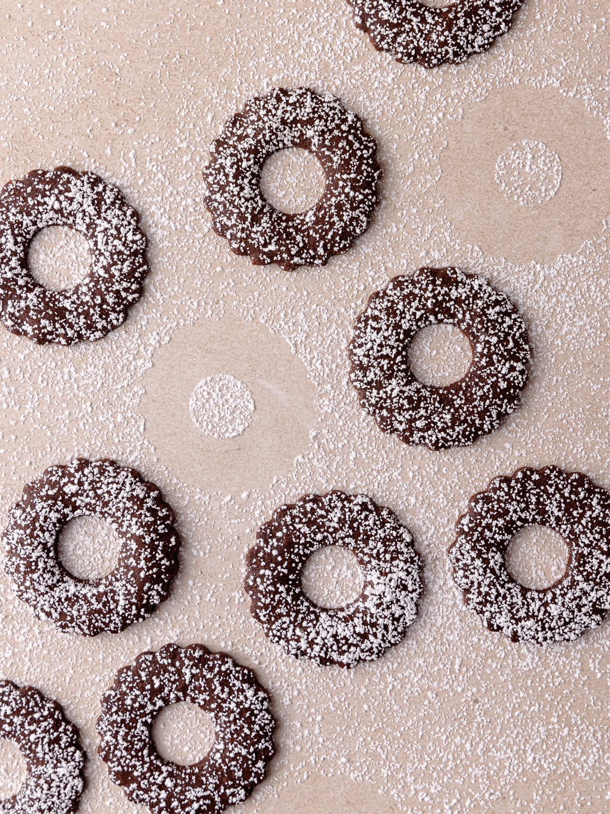 The top linzer cookies are dusted with powdered sugar.