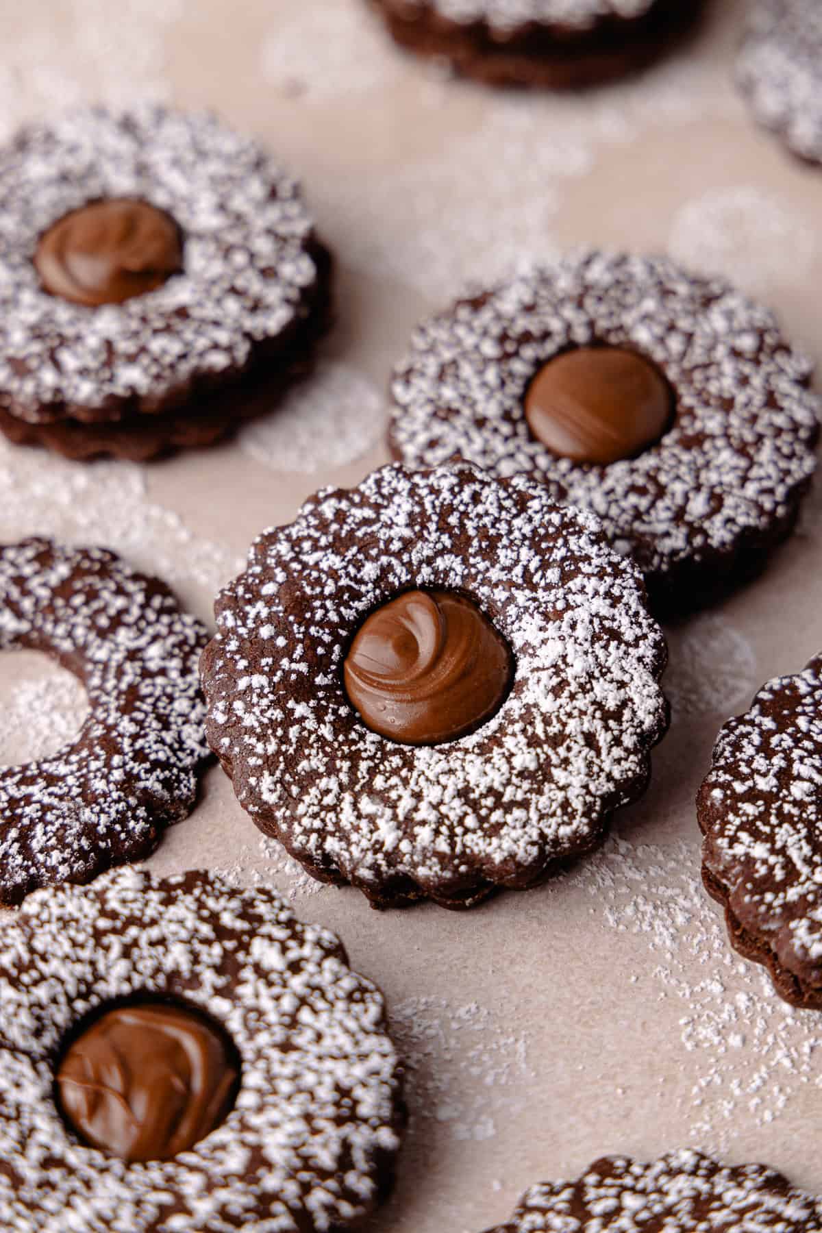 Nutella linzer sandwich cookies are dusted with powdered sugar and filled with Nutella featured photo.