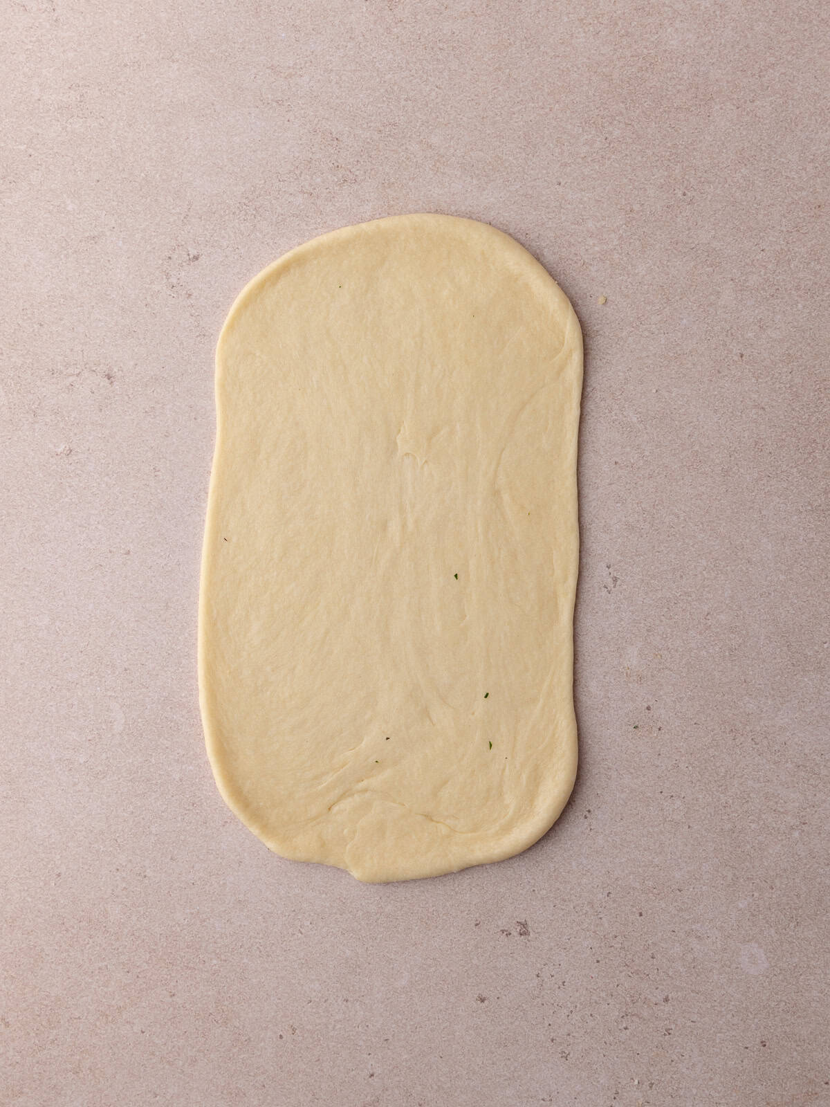 The ball of dough is rolled into an 8 inch by 5 inch rectangle.