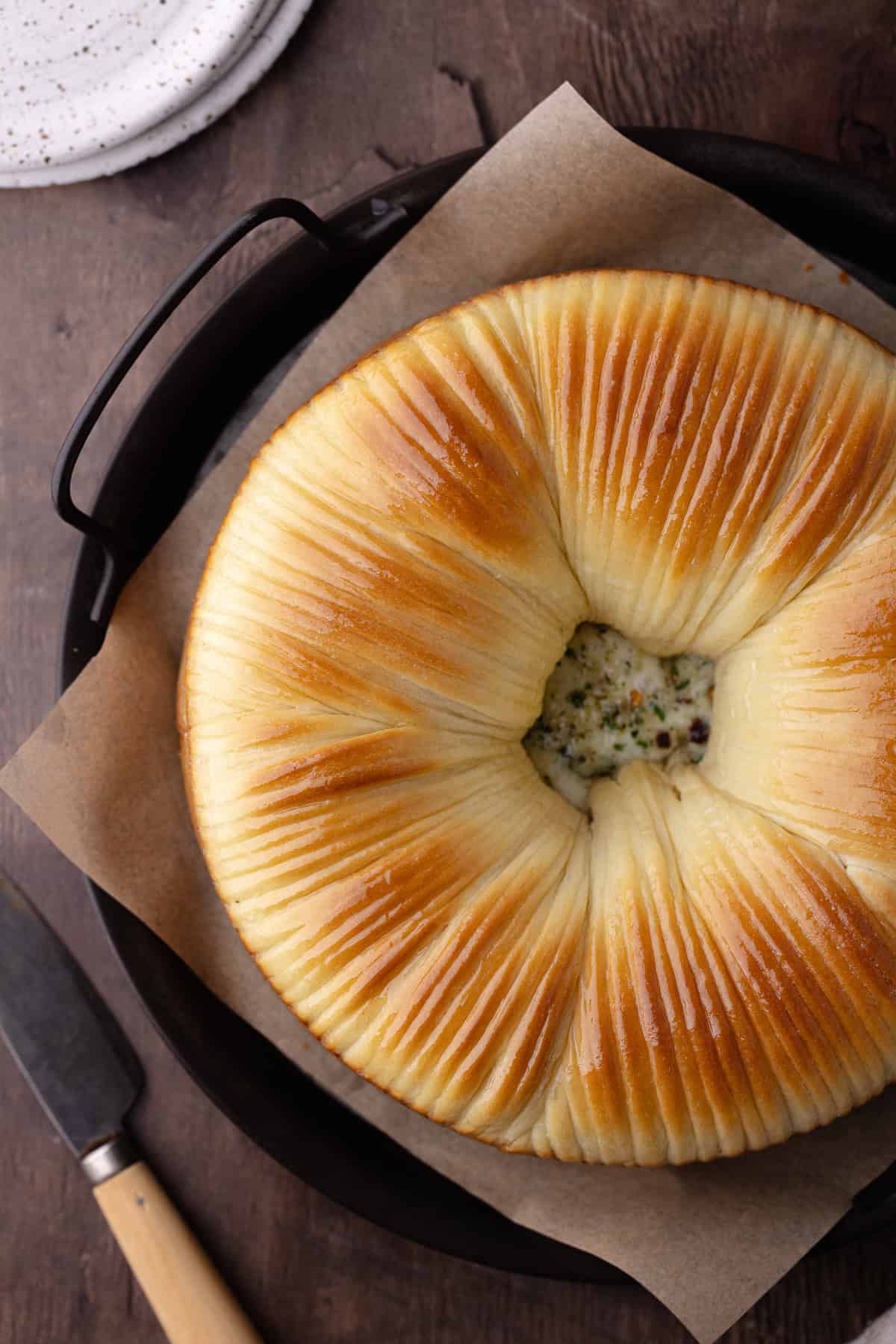 Savory wool bread with garlic, herbs and cheese sitting on a serving tray.