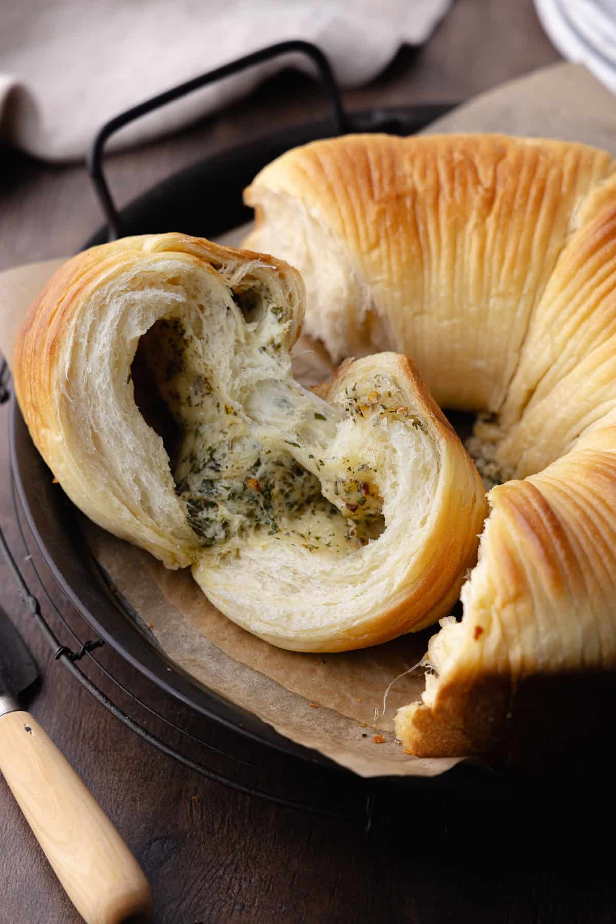 Close up of the inside of the savory wool bread shows garlic, herbs and cheese in the center of the bread. Texture is ultra soft and fluffy.