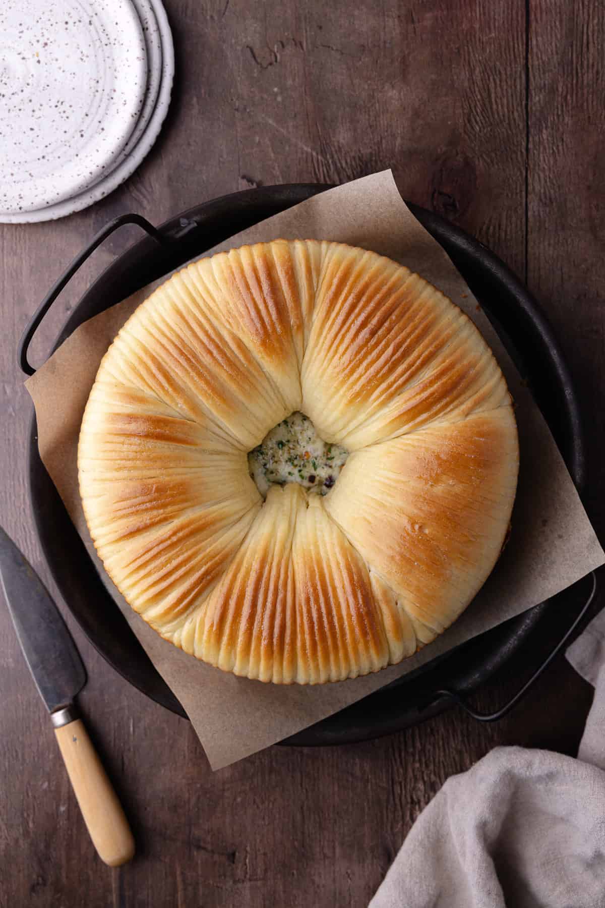 Savory wool bread with garlic, herbs and cheese sitting on a serving platter.