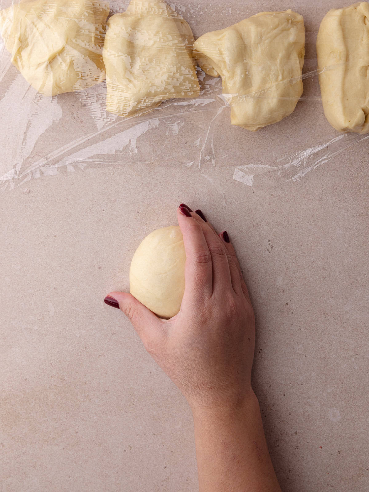 The dough is rolled into a smooth ball of dough.