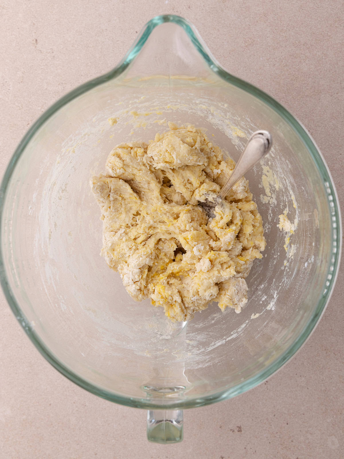 Shaggy Tangzhong wool bread dough sitting in a large glass mixing bowl.