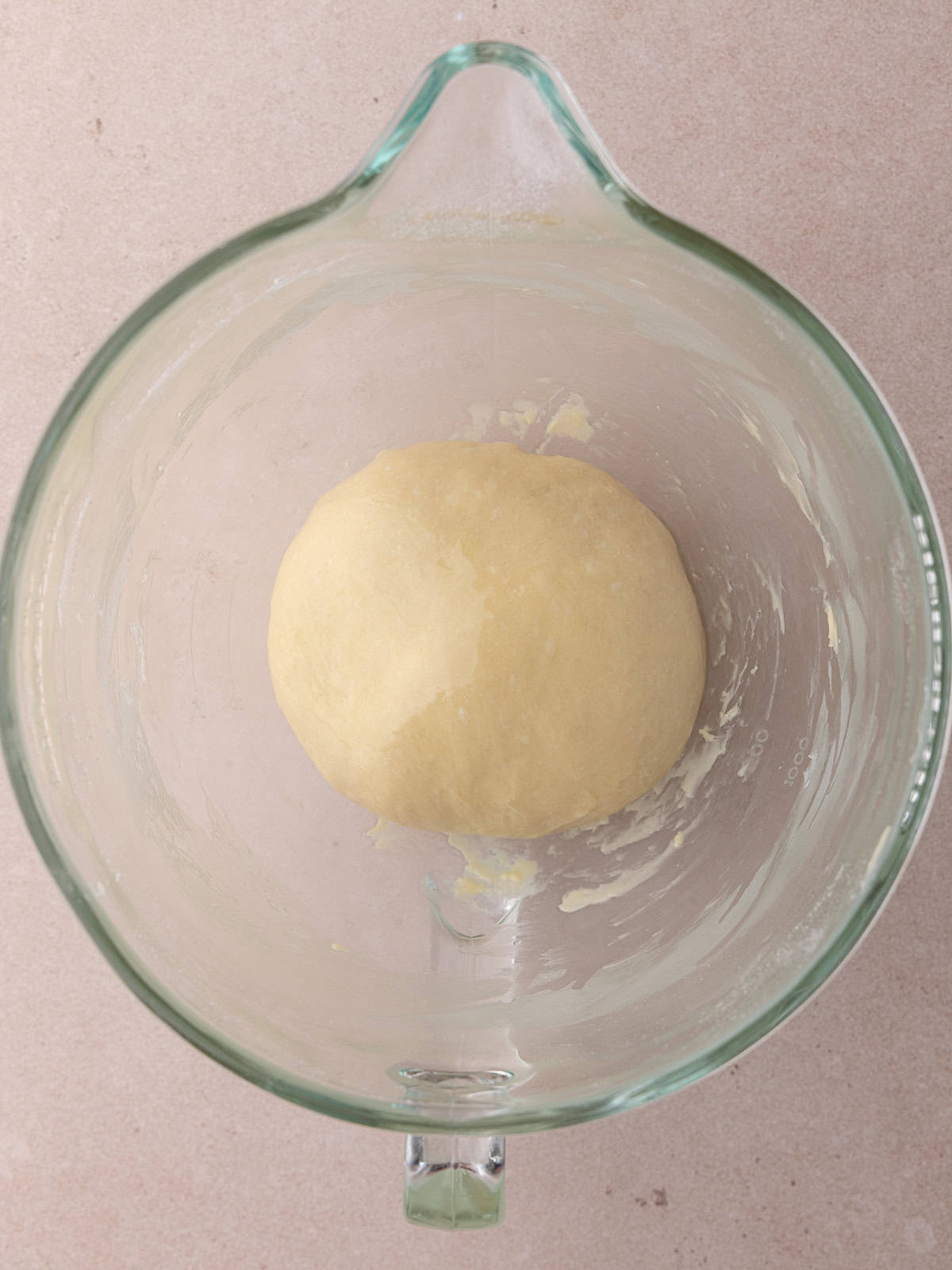 Tangzhong wool bread dough is formed into a smooth ball and sits in an oiled mixing bowl.