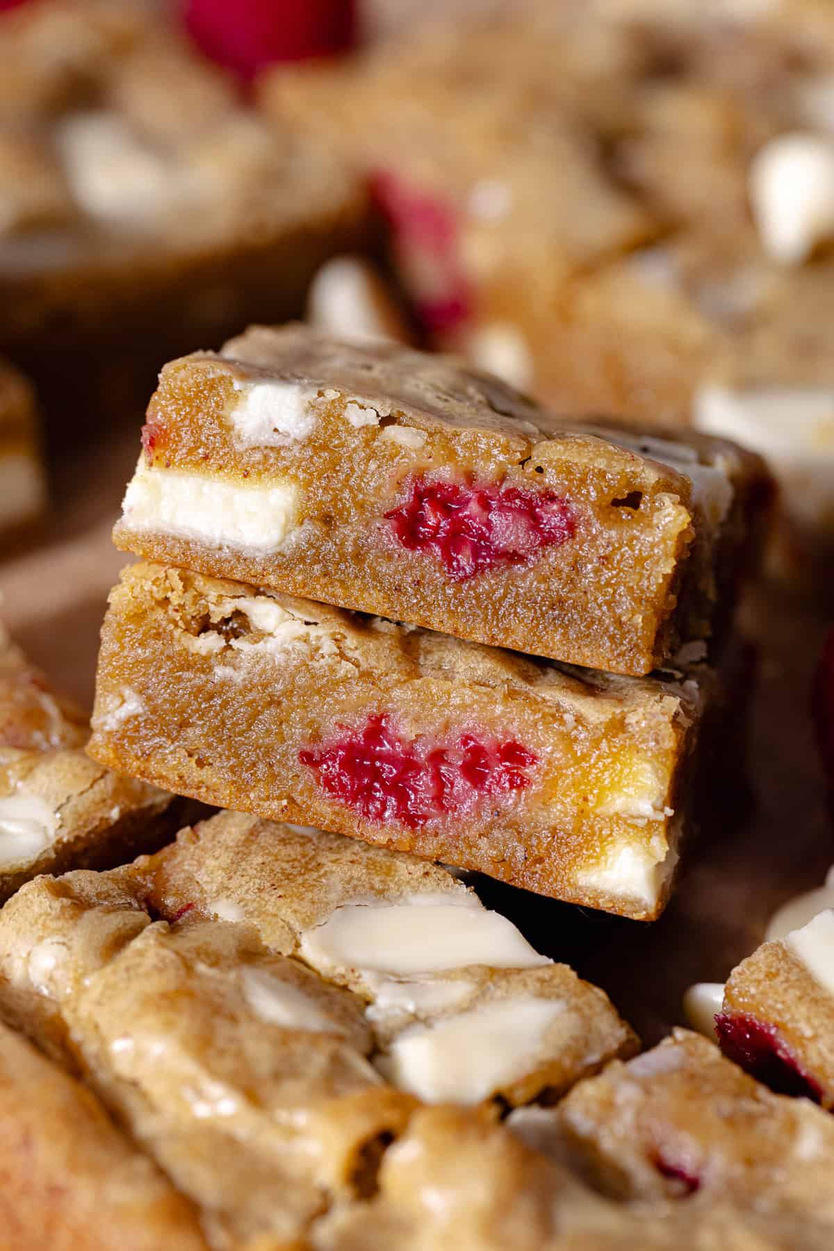 Gooey and fudgy brown butter raspberry and white chocolate blondies are cut into small squares.