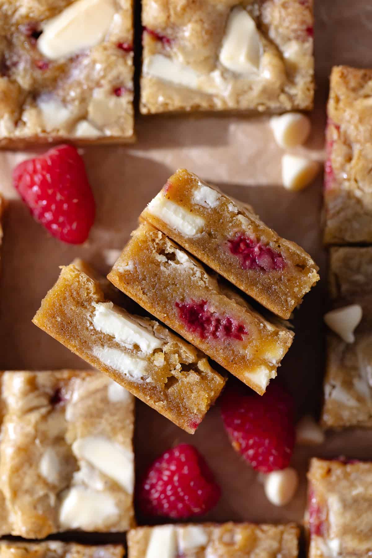 Gooey and fudgy brown butter raspberry and white chocolate blondies are cut into small squares.