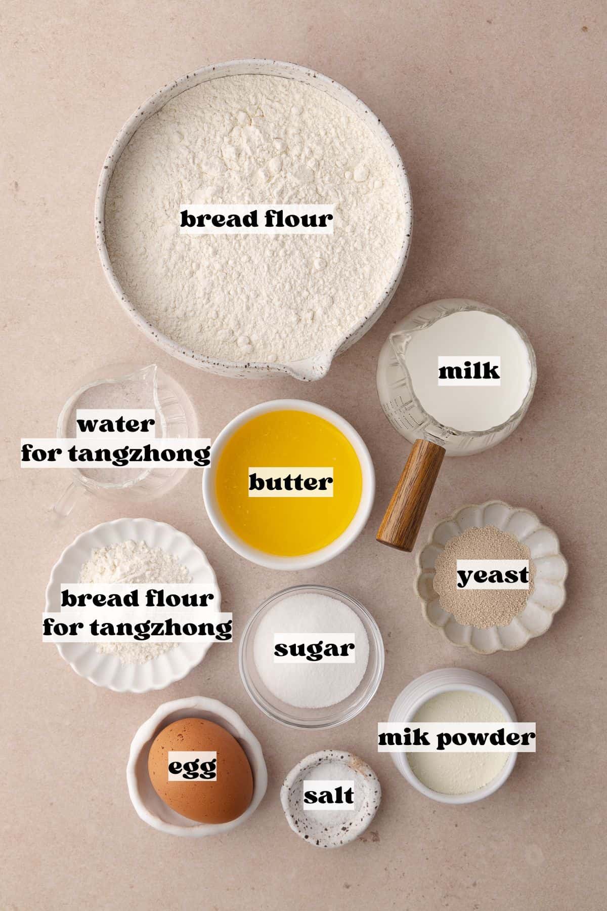 Tangzhong wool bread dough ingredients which include, bread flour, milk, water, yeast, egg, melted butter, salt, dry milk powder, and sugar.