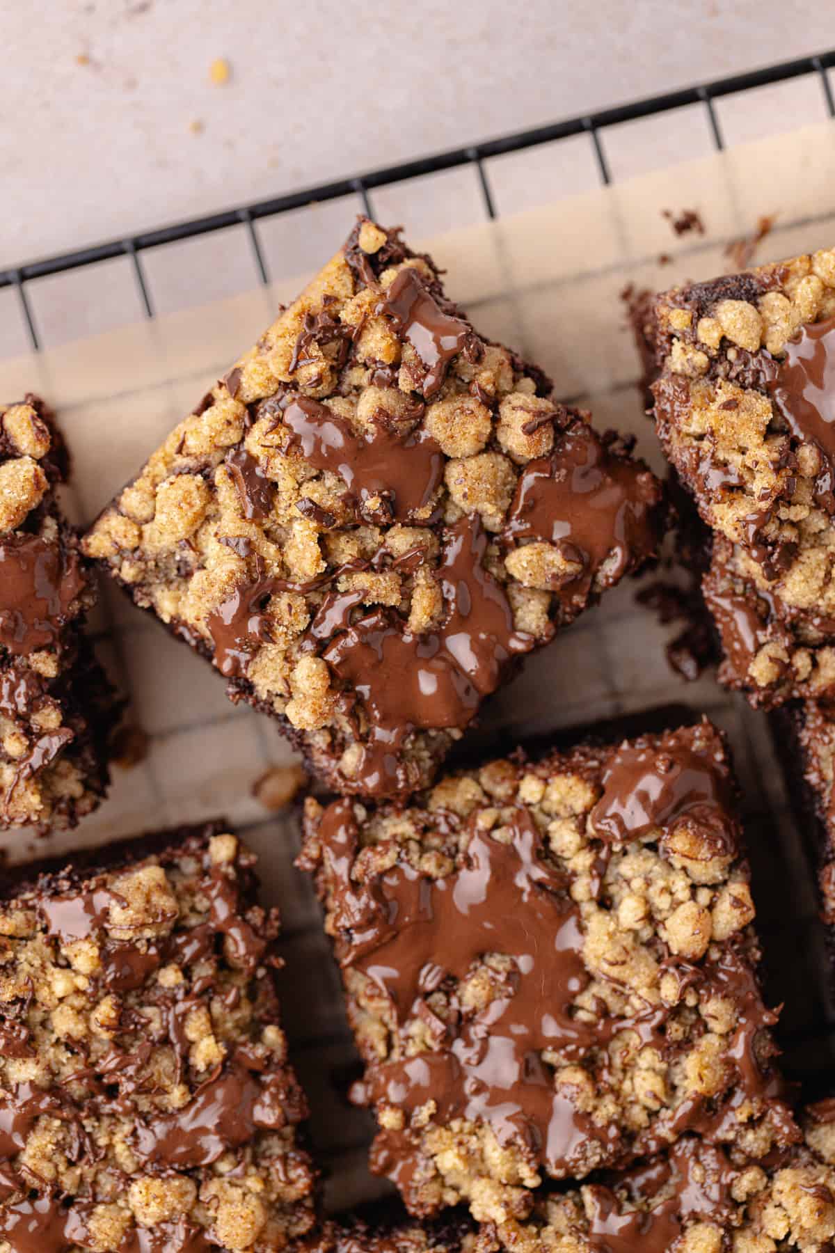 Close up chocolate coffee cake cut into squares sitting on a wire rack.