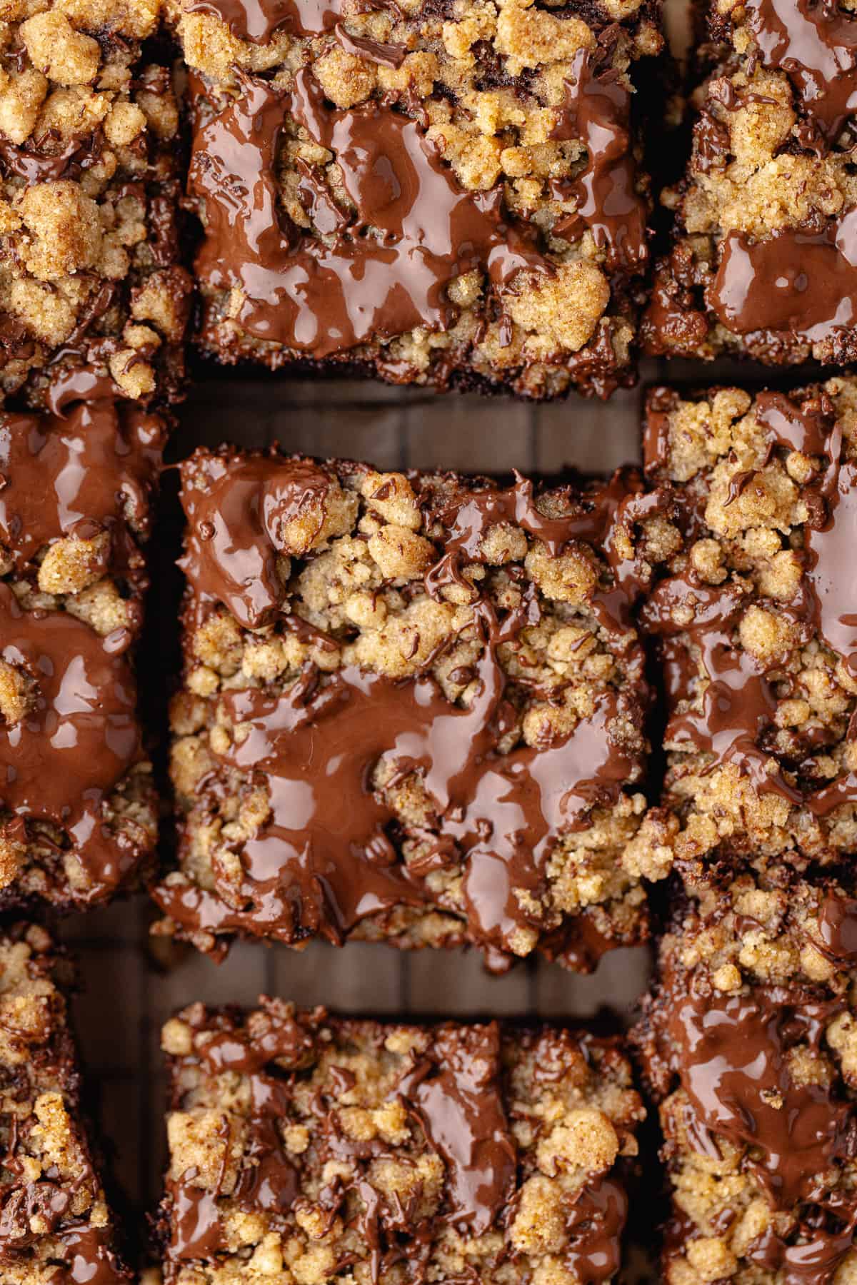 Close up chocolate coffee cake cut into squares sitting on a wire rack.