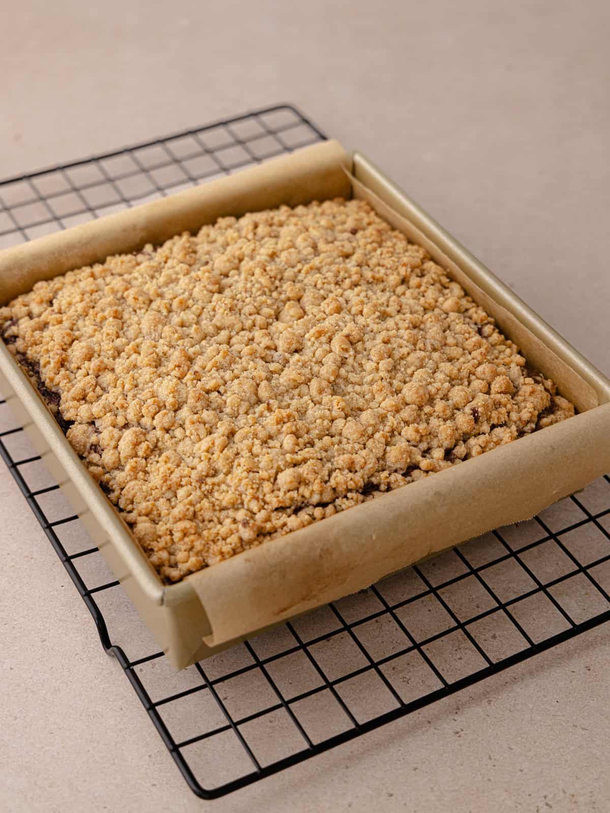 Chocolate coffee cake is baked and sitting on a wire rack to cool.