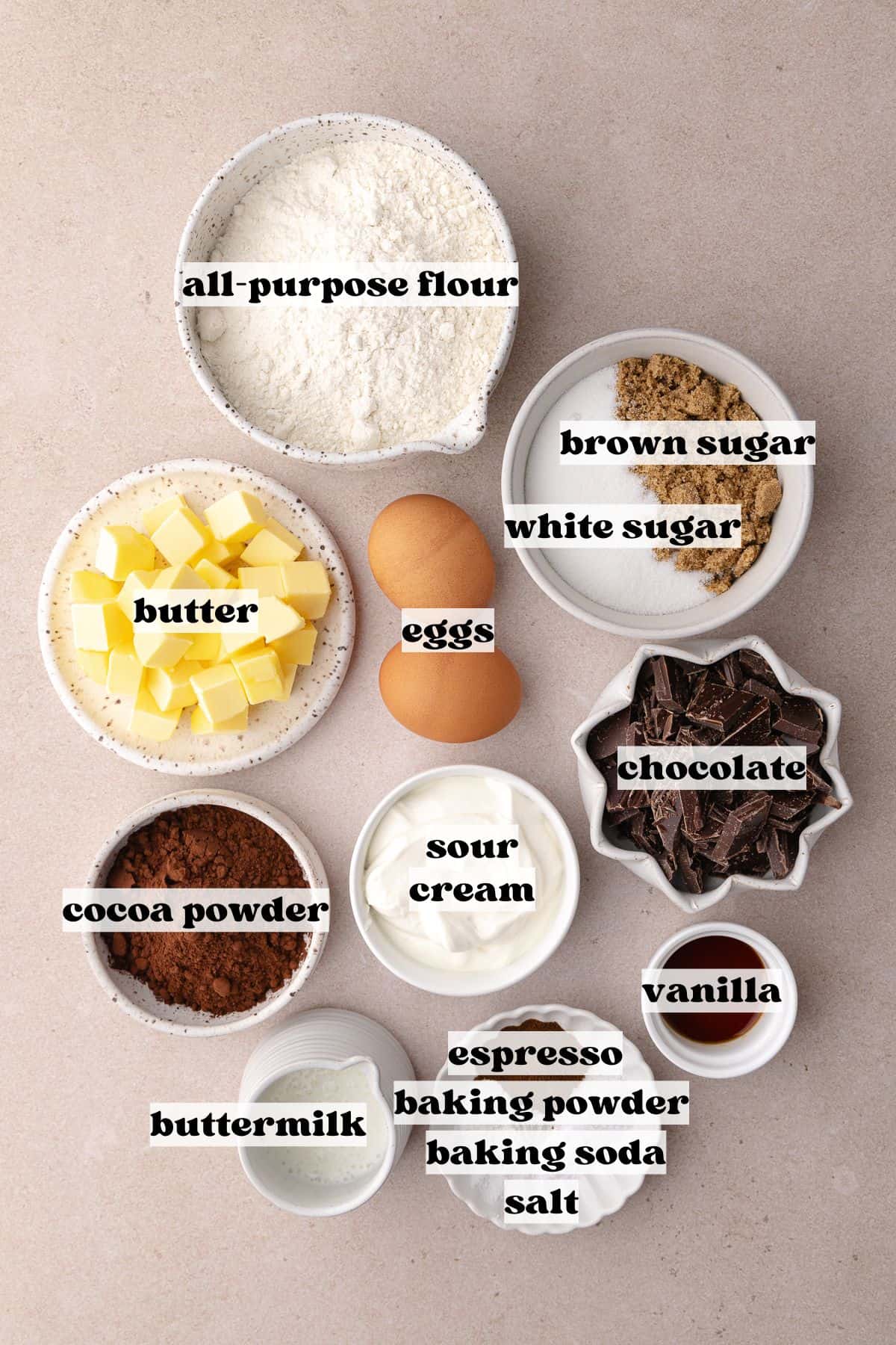 Chocolate coffee cake ingredients which include, flour, cocoa powder, espresso, baking powder, baking soda, salt, butter, white sugar, brown sugar, sour cream, buttermilk, vanilla, eggs and chocolate chunks.